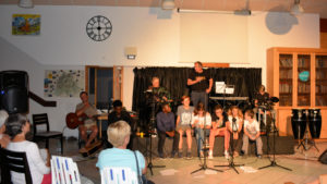 Philippe (guitare), Michael, Jamescy, Arthur, Marianne, Timothé, Charlotte, Sylvain. Au deuxième rang : Jean-Luc au piano, Xavier debout, Athis à la batterie.