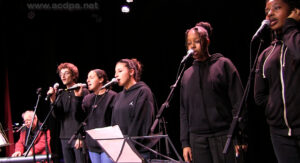 Jean-Luc au clavier ; Médi, Mégane, Neyla, Assa et Amour chantent « Jamais assez »